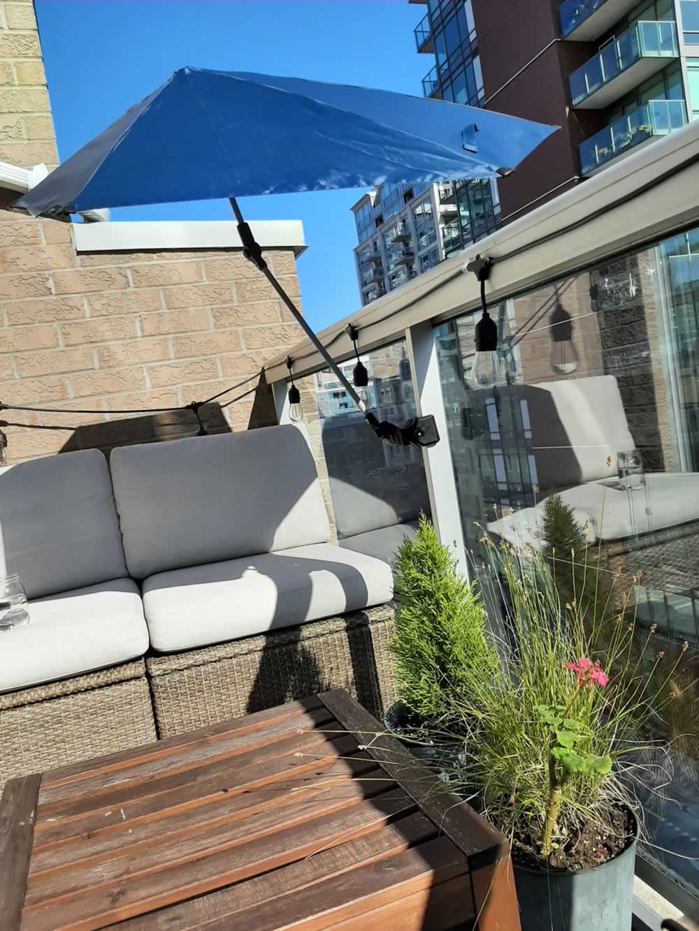 Balcony umbrella providing shade on seating area.
