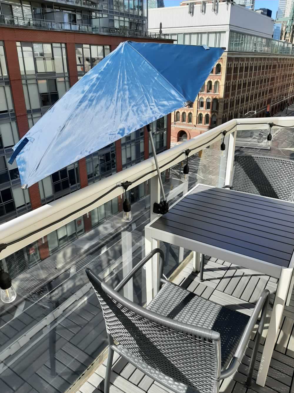 Balcony umbrella providing full shade to table.