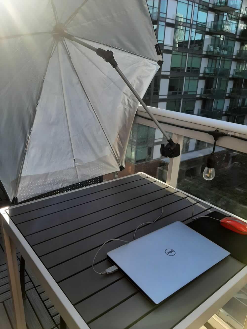 Balcony umbrella providing full shade for working, with sun coming from the east.