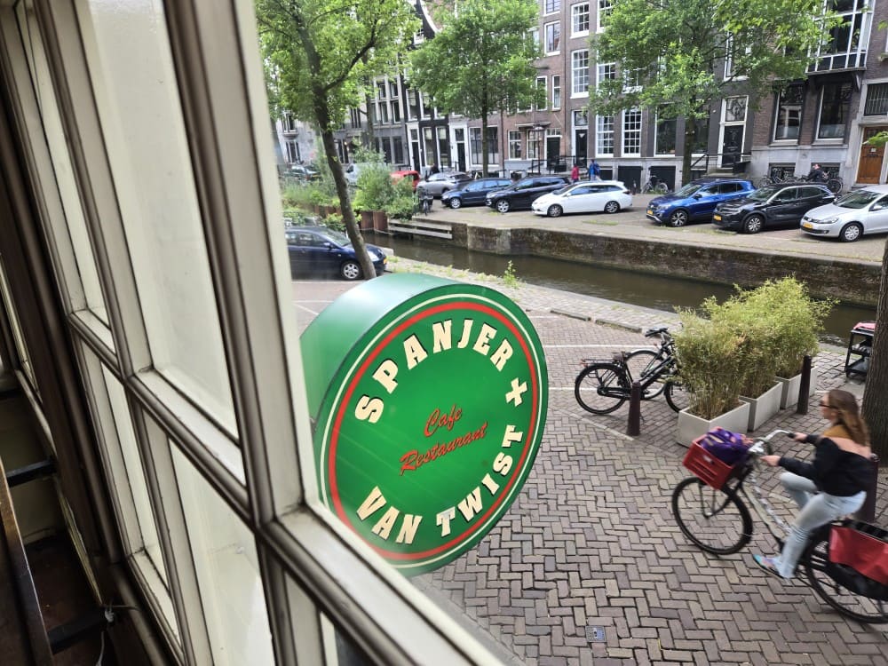 Bicyclist riding by Spanjer en van Twist, a Chilean restaurant in Amsterdam.